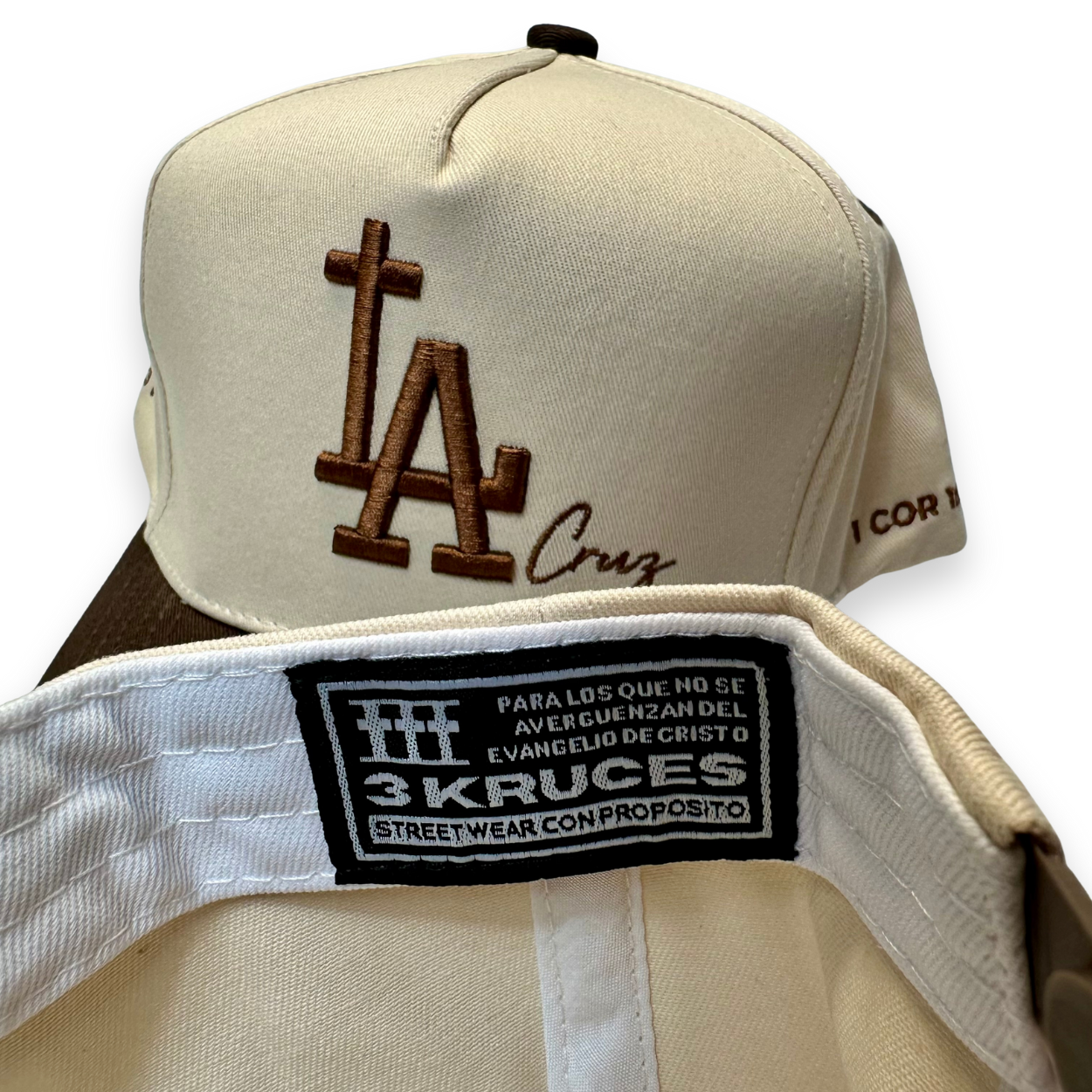 Beige cap with brown logo and '3 Krucés' label on a white background